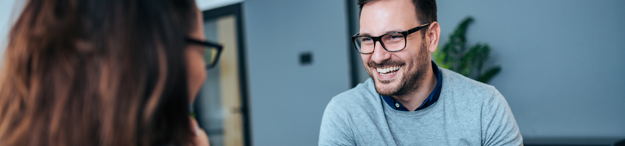 man holding clipboard interviewing woman